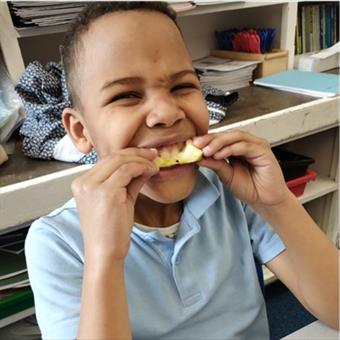 Child biting an apple